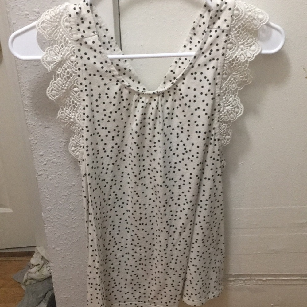 White dotted tank top with designs on it there is a cross on the back of it
